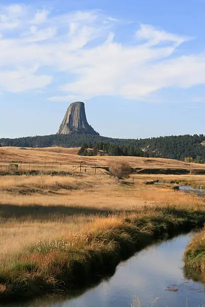 Devils Tower National Monument in Wyoming USA with a stream meandering through the foreground