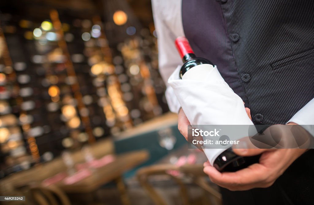 Man hoding a bottle of wine Unrecognizable man hoding a bottle of wine at a cellar Restaurant Stock Photo