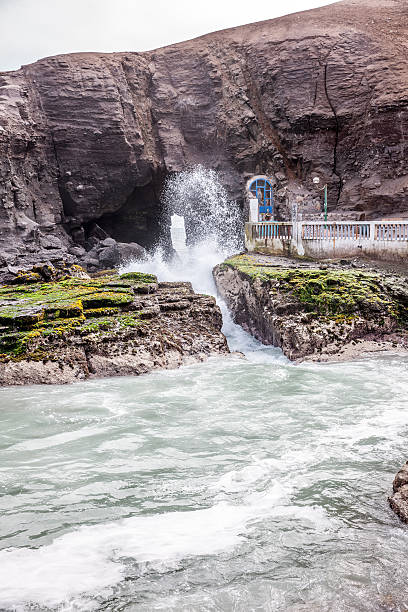istock Rushing tide through tunnel in sea cliffs 469213354