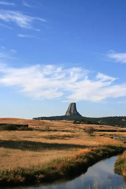 Devils Tower National Monument in Wyoming USA with a stream meandering through the foreground