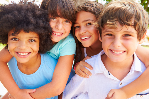 Group Of Children Giving Each Other Piggyback Rides