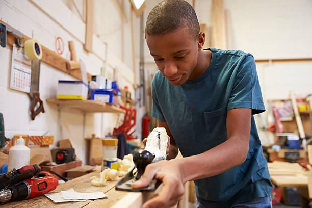istock Male apprentice measuring wood at carpentry workshop 469219636