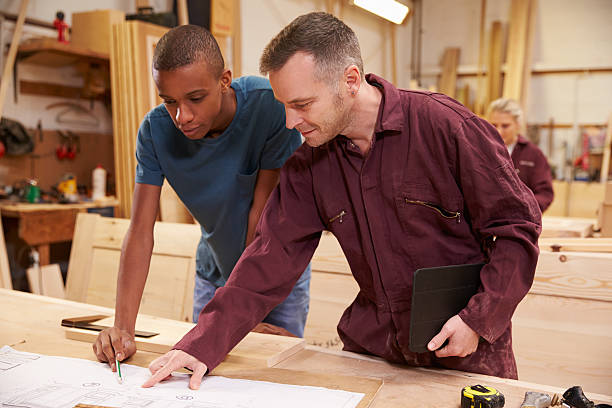 istock Two men in a workshop look at wood together 469220096