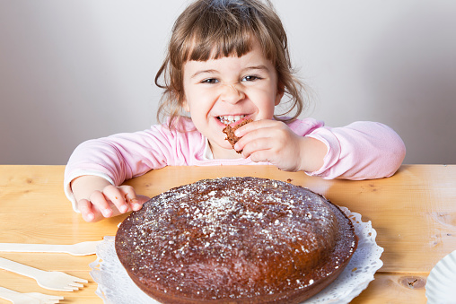 Very funny  and play toddler taking a piece of  delicious cake