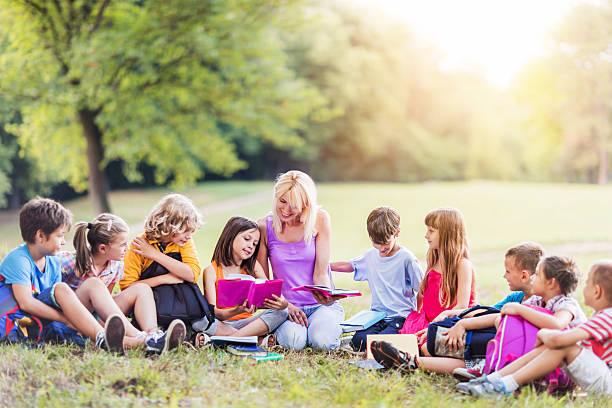 istock Group of school children having a class in the park. 469224356