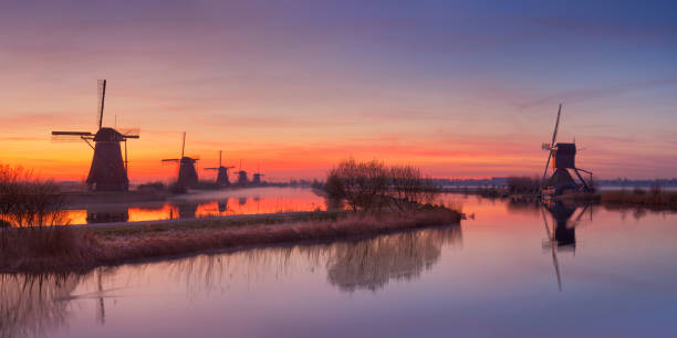 традиционные мельницами на рассвете, kinderdijk, нидерланды - polder windmill space landscape стоковые фото и изображения