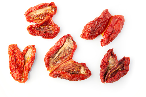 Five sun dried tomatoes on a white background