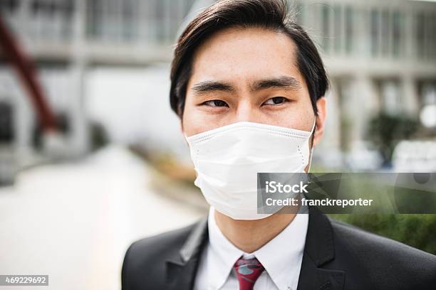 Japanese Businessman Standing On The City With A Pollution Mask Stock Photo - Download Image Now
