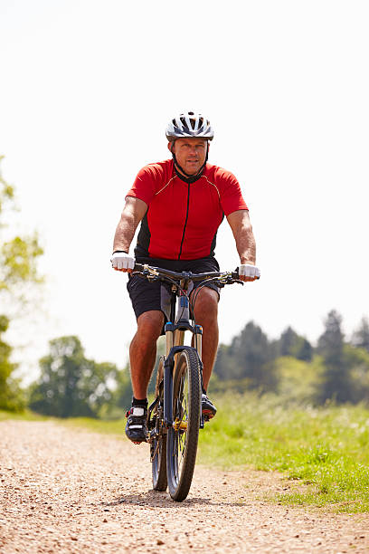 istock Man Riding Mountain Bike Along Path In Countryside 469229886