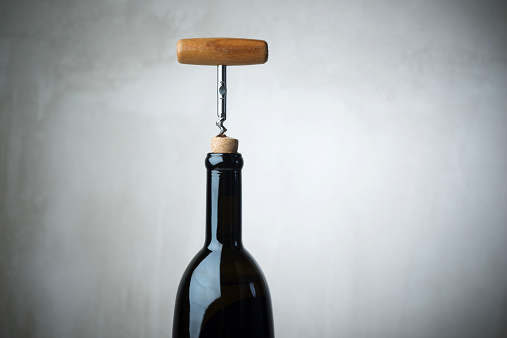 Corkscrew and wine bottle, opening a bottle of wine in celebration