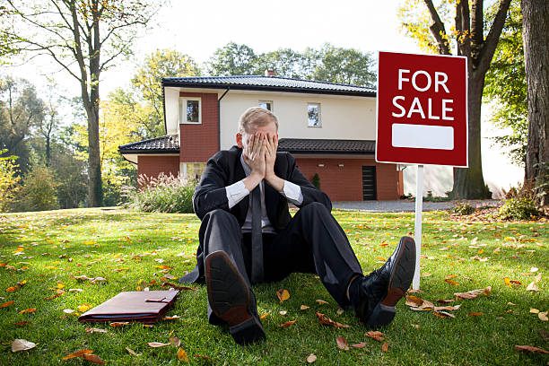 istock Tired estate agent is sitting on grass 469235172