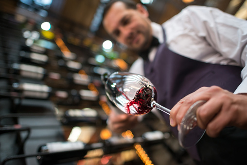 Sommelier pouring a glass of wine at a cellar