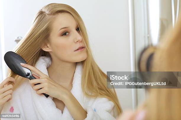 Woman Brushing Hair Stock Photo - Download Image Now - 20-24 Years, 2015, Adult