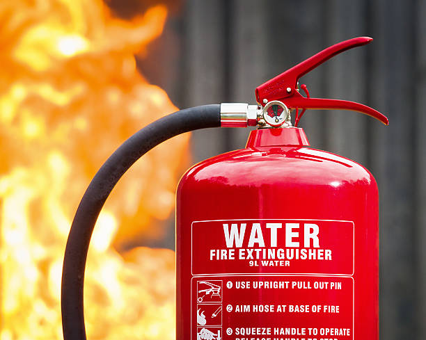 istock Water based fire extinguisher in front of flames 469247640