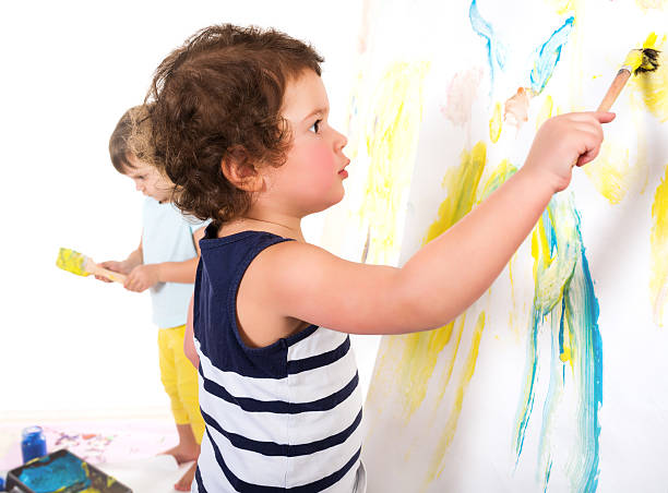 istock Small children draw paints on a paper wall 469251856
