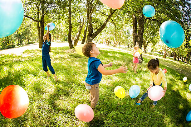 istock Happy children in a park having fun with balloons 469253194