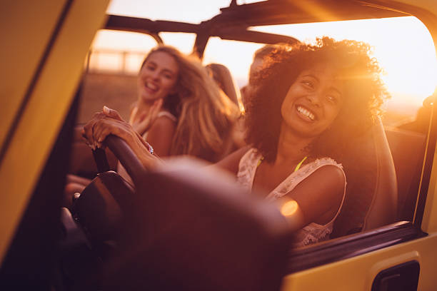 afro menina com os seus amigos em uma viagem em estrada ao pôr do sol - journey retro revival travel old fashioned imagens e fotografias de stock