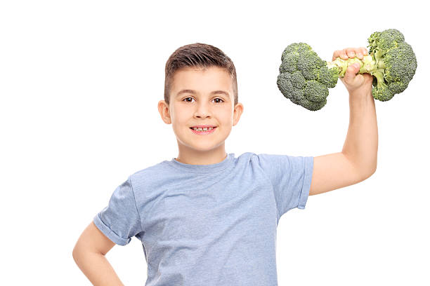 istock Little boy exercising with a broccoli dumbbell 469260068