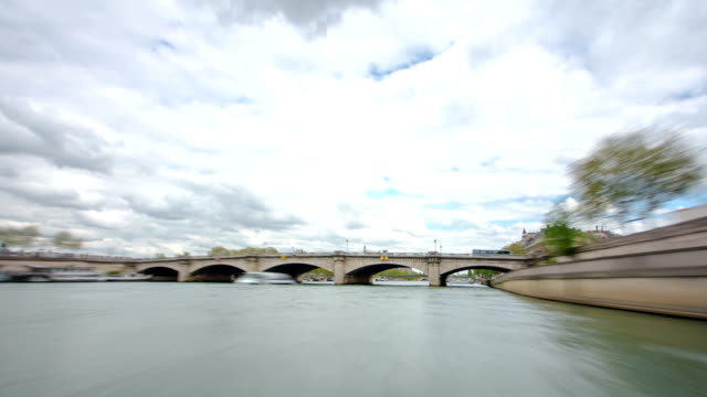 Paris. The excursion motor ship floats down the river Seine in the cloudy spring day timelapse