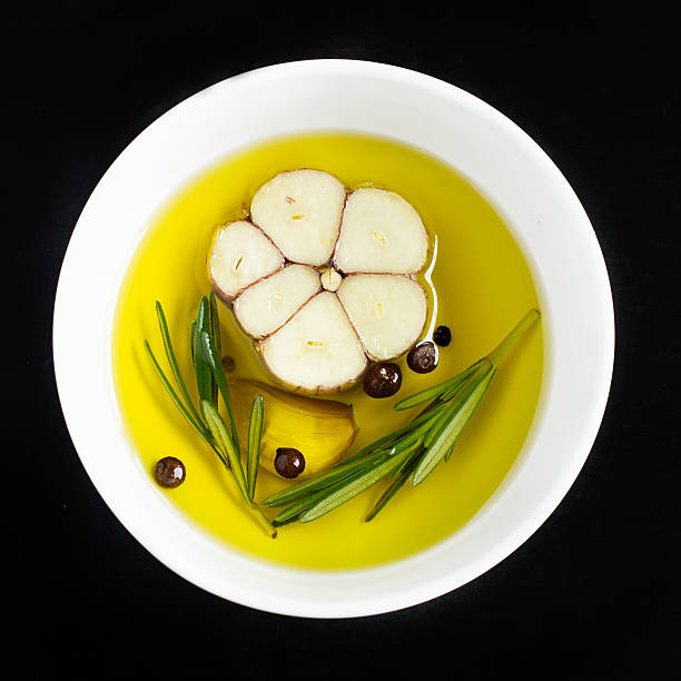 bowl with olive oil, garlic, ppeppercorn  and rosemary, top view
