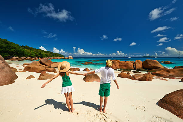 Couple in green having fun on a beach at Seychelles Couple in green having fun on a tropical beach at Seychelles praslin island stock pictures, royalty-free photos & images
