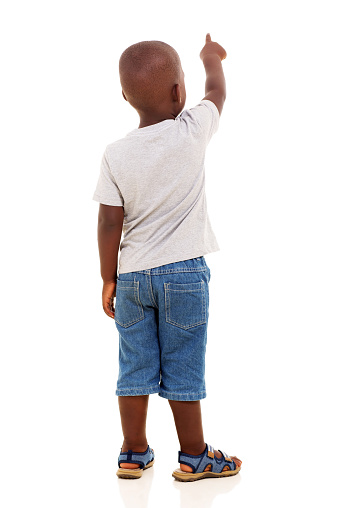 back view of little african boy pointing on white background