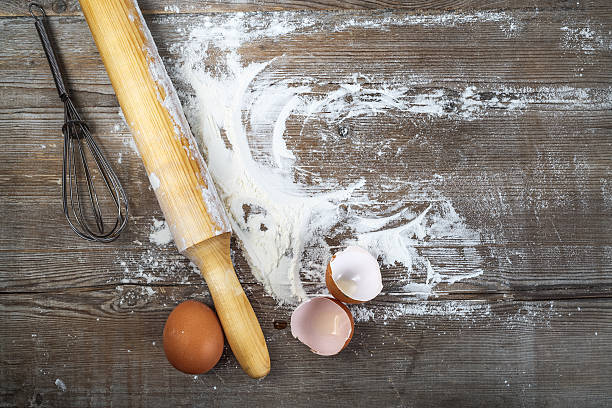 Cooking  background Eggs, eggshells, flour and rolling pin on wooden background. Top view. flour mess stock pictures, royalty-free photos & images