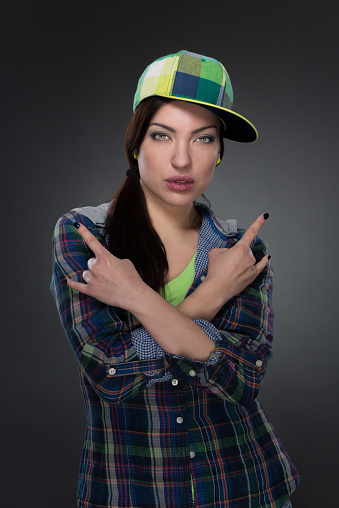 Portrait of street dancer in cap on grey background