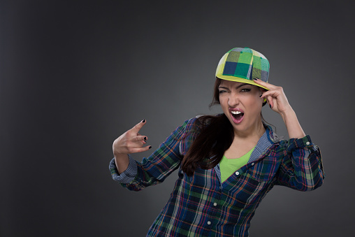 Portrait of street dancer in cap on grey background