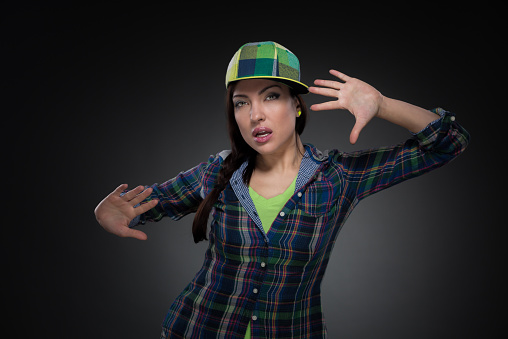 Portrait of street dancer in cap on grey background