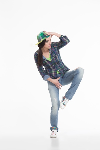 Portrait of street dancer in cap on white background