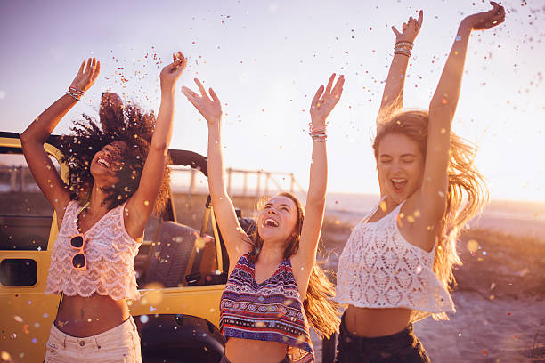 istock Mixed racial group dancing on a beach with confetti 469282666
