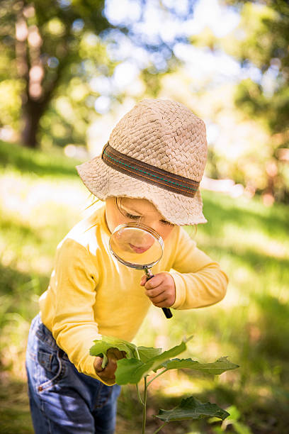 istock Curious toddler studying a leaf with a magnifying glass 469282936