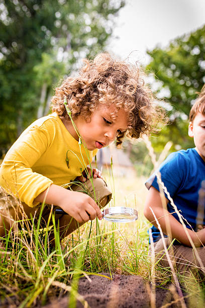 istock Curious African American boy using magnifying glass to study ins 469282944