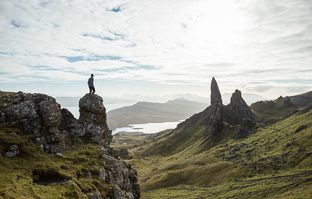Man surrounded by epic cliffs on the isle of Skye in Scotland whilst the sun goes downMan surrounded by epic cliffs on the isle of Skye in Scotland whilst the sun goes down