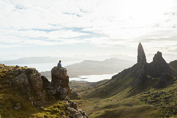 Man surrounded by epic cliffs on the isle of Skye in Scotland whilst the sun goes downMan surrounded by epic cliffs on the isle of Skye in Scotland whilst the sun goes down