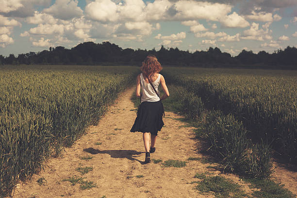 istock Young woman walking in a wheat field 469289210
