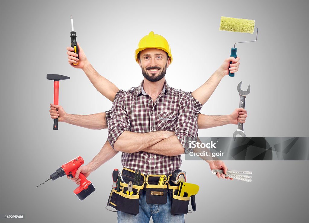 Handyman with tools Cheerful carpenter looking at camera with tolls in six hands Work Tool Stock Photo