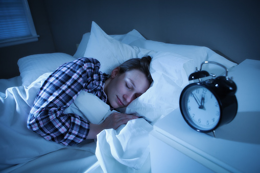 Mujer durmiendo pacífica y profundamente en la cama con la ropa de cama Sweet Dreams photo