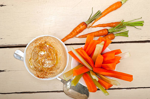 fresh hummus dip with raw carrot and celery