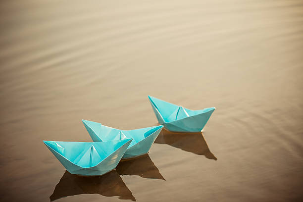 istock Paper boat on the water 469305410