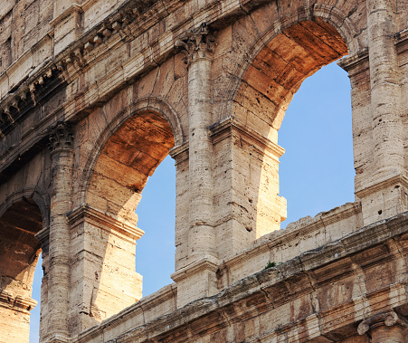Close-up image showing the sky through external arches of the Colosseum (Flavian Amphitheatre) in central Rome, Italy.