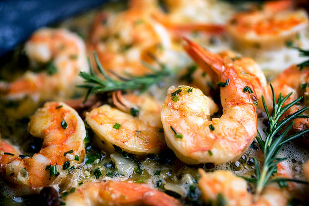 Jumbo Shrimp Scampi Sauteeing in Butter and Olive Oil Close image of jumbo shrimp being sauteed in a pan with oregano, chive, rosemary, garlic and paprica creating Shrimp Scampi savory food photos stock pictures, royalty-free photos & images