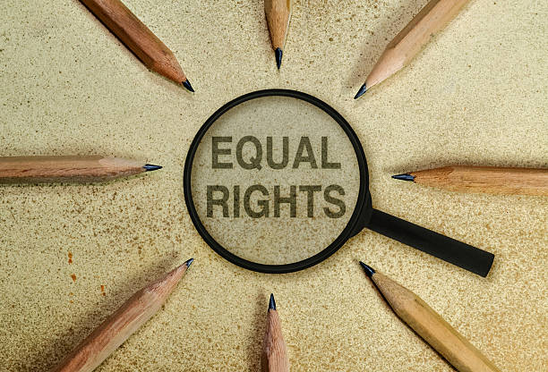 Equal rights Text under a magnifier in a conceptual image as appeal to respect human rights. Eight wooden pencils arranged in a circle and the magnifrier  set in the middle with words EQUAL RIGHTS on a vintage background. segregation stock pictures, royalty-free photos & images