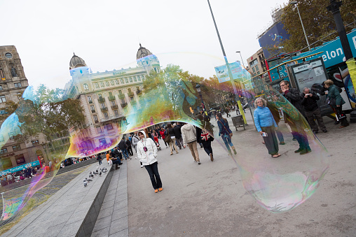 Barcelona, Spain – November 08, 2014: Romanian Gypsy migrants are making a living producing giant soap bubbles to amuse passing-by tourists