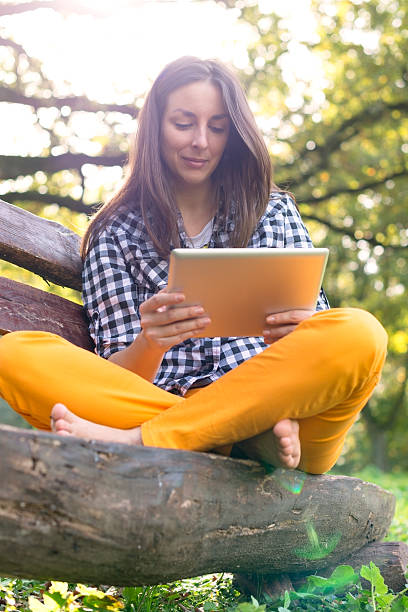 istock Young Woman using digital Tablet in Park 469321044