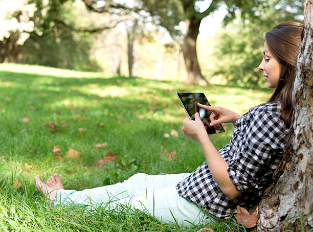 istock Young Woman using digital Tablet in Park 469321050