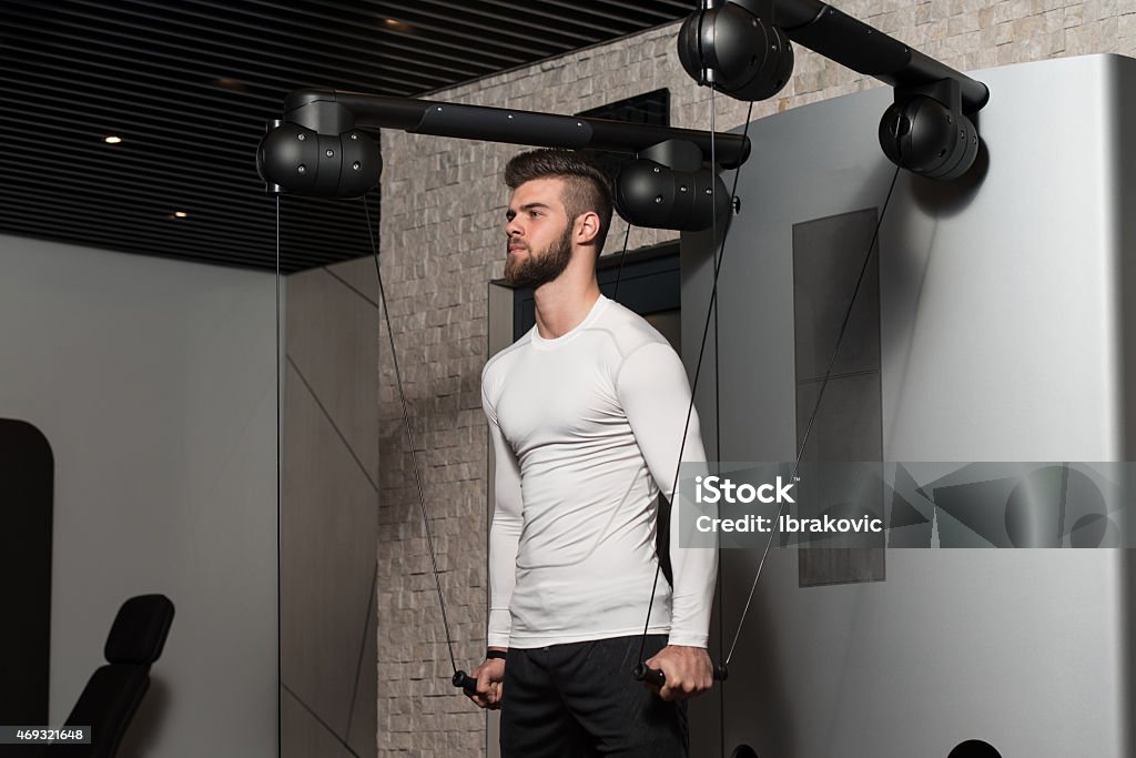 Healthy Young Man Doing Exercise For Shoulders Handsome Man Is Working On His Shoulders With Cable Crossover In A Modern Gym Teenage Boys Stock Photo