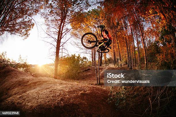 Exteme Mountain Biker Performing Aerial Maneuvers While Dirt Jum Stock Photo - Download Image Now