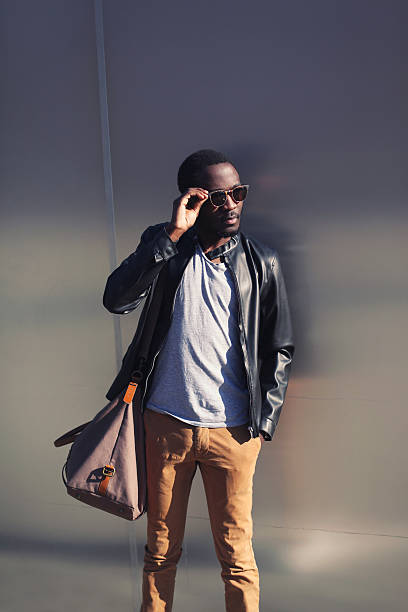istock Handsome african man in leather jacket and sunglasses against th 469326068